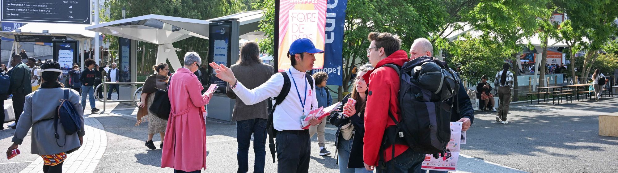 Un agent d’accueil renseigne des visiteurs à l'entrée de la Foire de Paris