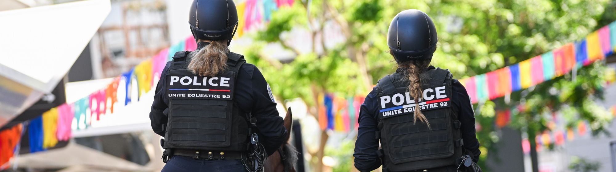 Deux policières à cheval patrouillant à la Foire de Paris, vue arrière