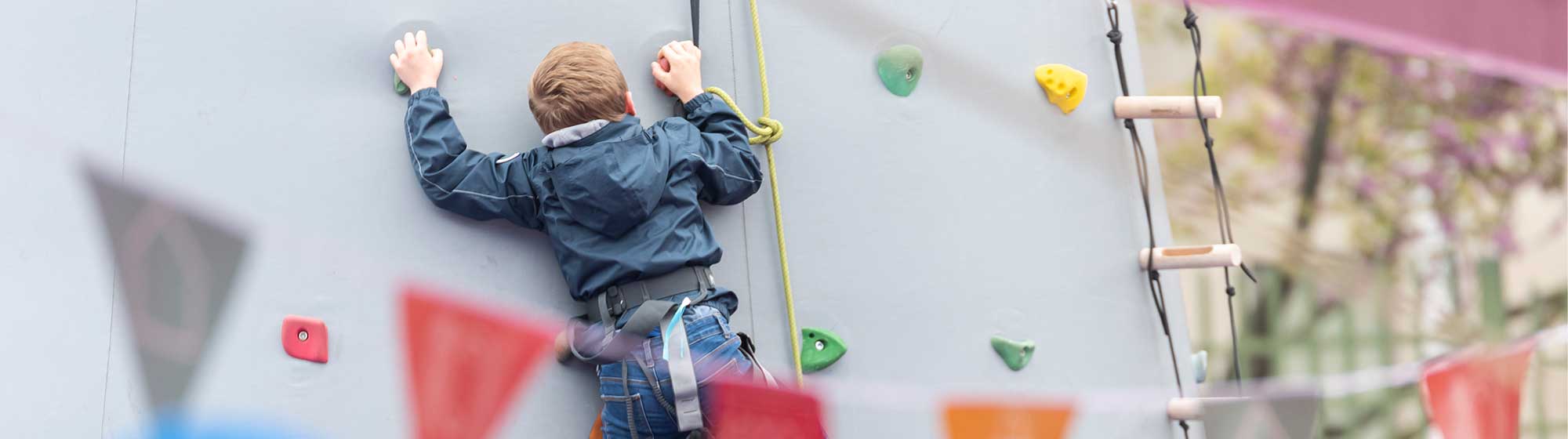 enfant escaladant le mur d'escalade mis en place sur Foire de Paris