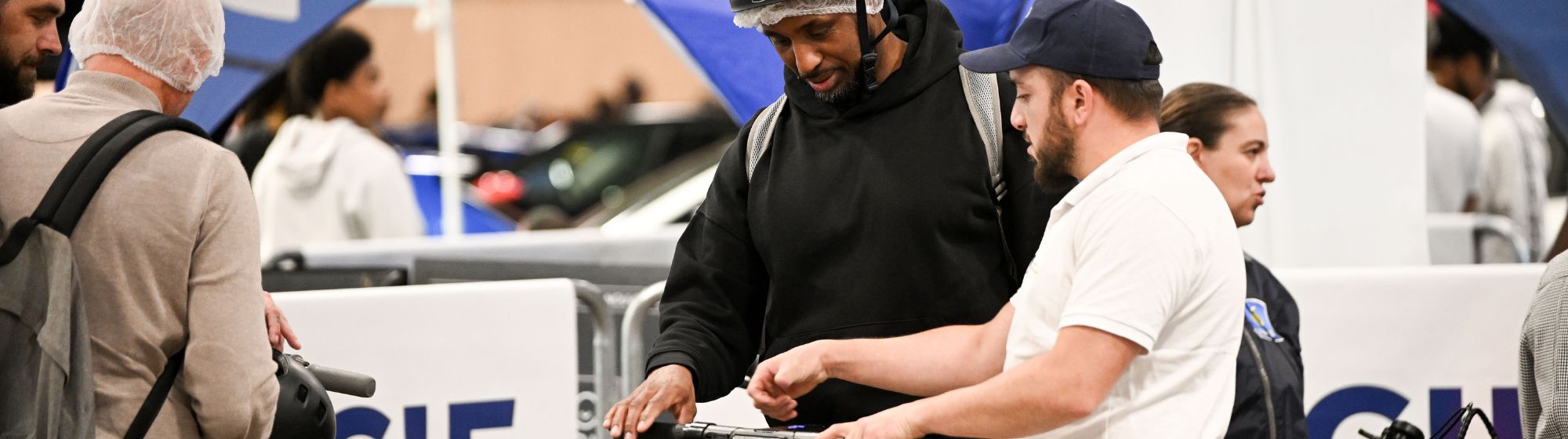 Essai de trottinette électrique encadré par un conseiller sur le stand MACIF lors d’un salon de la mobilité urbaine