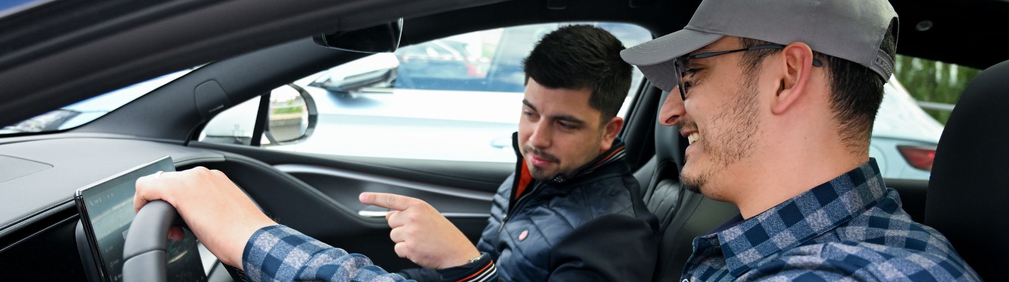Essai d’une voiture électrique avec écran tactile par deux visiteurs à Foire de Paris