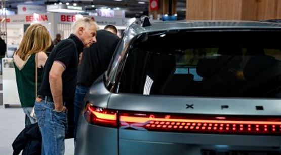 Public examinant un véhicule électrique XPENG sur un stand automobile à la Foire de Paris