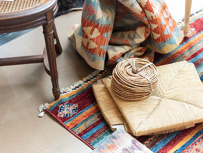 Création artisanale du dessus de chaise au milieu de chaises et de tapis faits mains