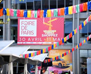 Façade du parc des expositions avec l'affiche de la Foire de Paris et des guirlandes colorées