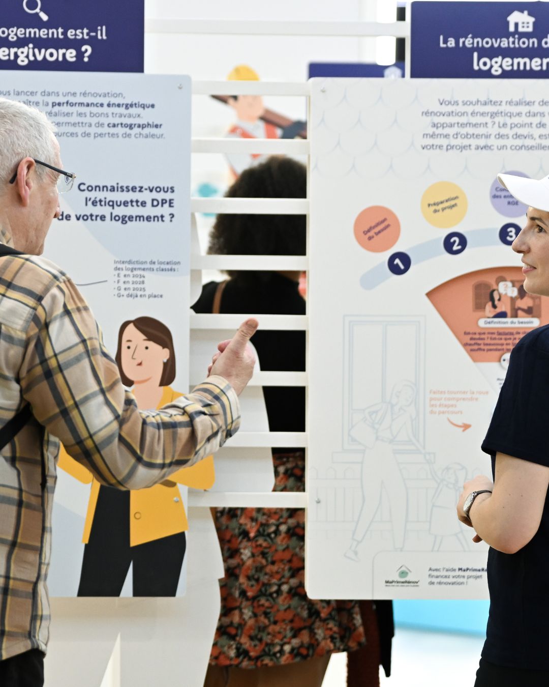 Visiteur recevant des conseils sur la rénovation énergétique de son logement sur le stand France Rénov à foire de paris