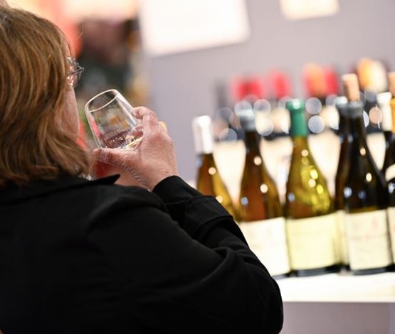 Visiteur de Foire de Paris buvant un verre de vin sur un stand sommelier