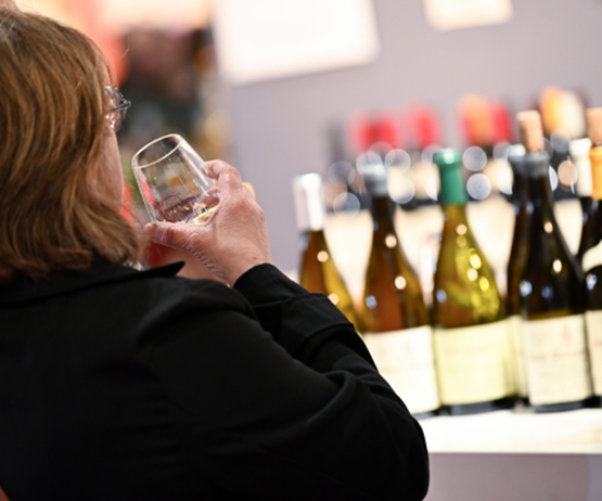 Visiteur de Foire de Paris buvant un verre de vin sur un stand sommelier