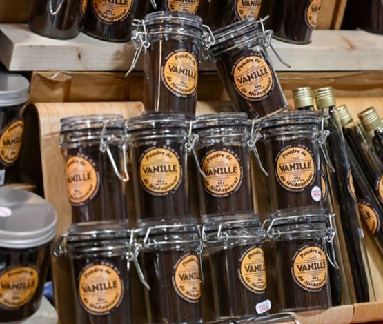Pots de poudre de vanille de Madagascar empilés sur un stand de marché