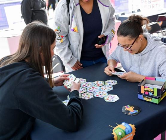 Deux jeunes femmes jouent au jeu de cartes Dobble Connect