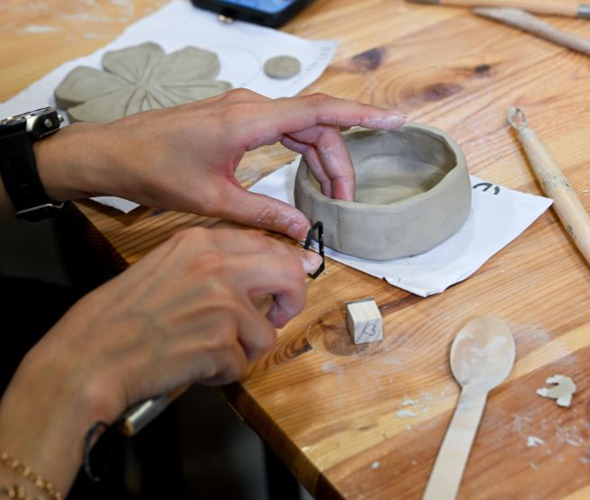 un visiteur façonne un bol en argile