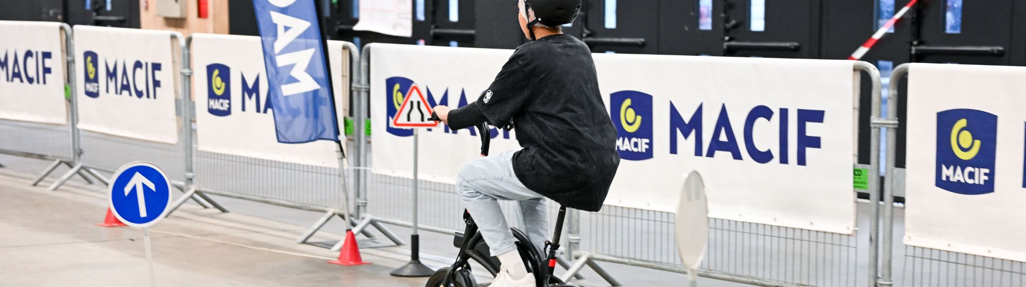 Jeune garçon testant un vélo sur un circuit de prévention routière organisé par la MACIF