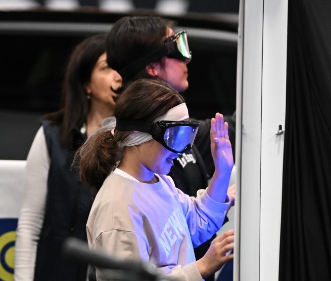 Jeune fille portant des lunettes de simulation d’alcoolémie lors d’un atelier de sensibilisation
