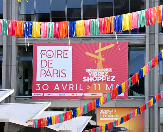 Banderoles colorées et grande affiche de la Foire de Paris annonçant les dates de l'événement