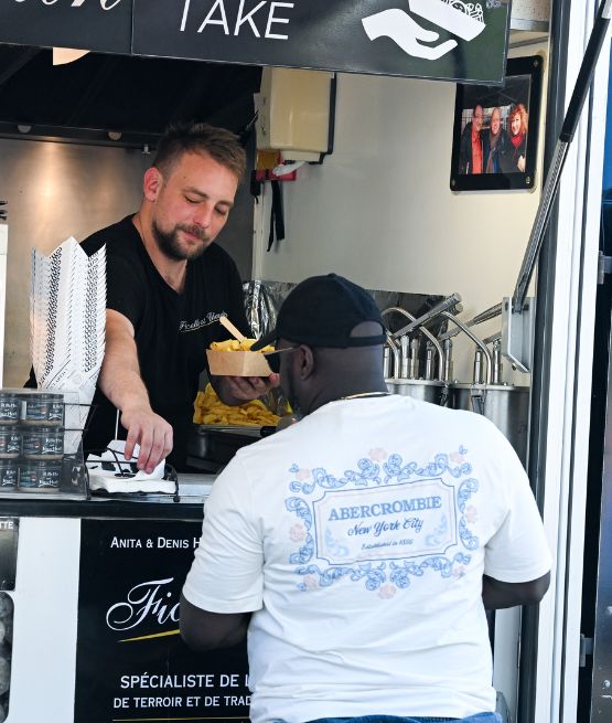 Vendeur de food truck servant des frites à un client lors de la Foire de Paris