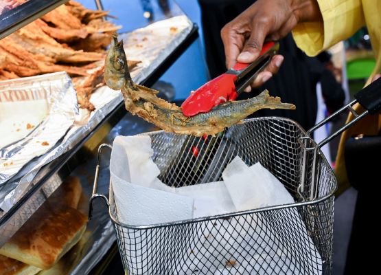 Poisson frit servi à la Foire de Paris dans une barquette avec pince rouge
