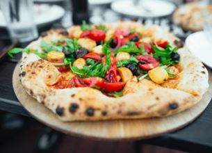 Pizza garnie de légumes colorés sur une pâte artisanale