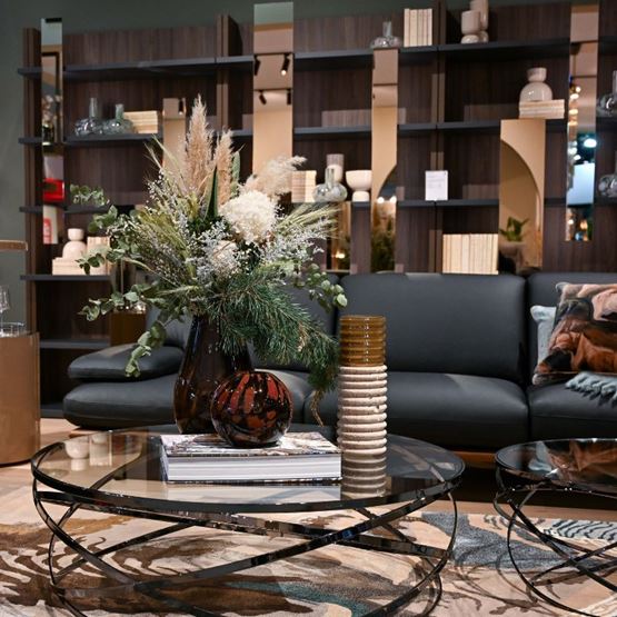 Salon moderne avec une table basse en verre et un bouquet de fleurs décoratives sur Home & Co Paris